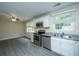 Modern kitchen featuring stainless steel appliances, granite countertops, white cabinets, and stylish flooring at 2003 Savage Rd, Charleston, SC 29407