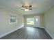 Spacious living room with modern flooring, neutral walls, large windows, and a ceiling fan at 2003 Savage Rd, Charleston, SC 29407