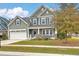 Attractive home with a well-maintained lawn, covered front porch, and a two-car garage on a sunny day at 202 Center Hill Ct, Summerville, SC 29485