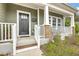 Inviting covered front porch with white railings, brick-based columns, and a welcoming front door with glass panes at 202 Center Hill Ct, Summerville, SC 29485
