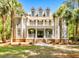 Stately two-story home featuring a double porch, dormer windows, and a well-manicured lawn with palm trees at 2225 Black Oak Ct, Mount Pleasant, SC 29466