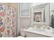 Bathroom with a white vanity, decorative mirror, and a shower featuring a seashell-themed curtain at 259 Camber Rd, Huger, SC 29450