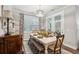 Bright dining room featuring a stylish white table, wood chairs and bench, and elegant light fixture at 259 Camber Rd, Huger, SC 29450