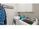 Bright laundry room with white cabinets, modern washer and dryer, and charming laundry room decor at 259 Camber Rd, Huger, SC 29450
