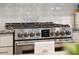 Close-up of the stainless steel range and oven with white subway tile backsplash and granite countertops at 259 Camber Rd, Huger, SC 29450