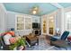 Cozy sunroom with blue ceiling, fireplace, comfortable seating and view to kitchen and dining area at 259 Camber Rd, Huger, SC 29450