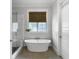 Elegant bathroom featuring a freestanding tub, a window, and a separate glass-enclosed shower at 2769 Rivertowne Pkwy, Mount Pleasant, SC 29466