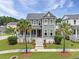 Charming two-story home featuring a covered front porch, manicured lawn, and mature palm trees at 2769 Rivertowne Pkwy, Mount Pleasant, SC 29466