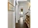 Hallway with hardwood floors and view into a bedroom; convenient built-in shelving on right at 2769 Rivertowne Pkwy, Mount Pleasant, SC 29466