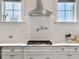 Close-up view of the kitchen counter, sink, subway tile backsplash, and stainless steel range hood at 2769 Rivertowne Pkwy, Mount Pleasant, SC 29466