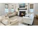 Cozy living room with a fireplace, large windows, and comfortable white, textured furniture at 2769 Rivertowne Pkwy, Mount Pleasant, SC 29466