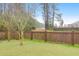 Serene backyard with a lush green lawn and privacy fence bordering a scenic wooded area with a pond at 281 Decatur Dr, Summerville, SC 29486