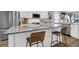 Close-up of kitchen island with granite countertop, bar stools, stainless steel appliances, and ample cabinet space at 3 Clearblue Loop, Summerville, SC 29486