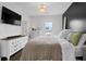 Bright main bedroom features elegant chandelier, TV, and large dresser with view to the outside at 3 Clearblue Loop, Summerville, SC 29486