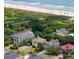 An aerial view shows stunning beach-adjacent homes, with lush greenery and pristine sandy shores nearby at 30 Beachside Dr, Isle of Palms, SC 29451