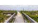 Scenic beach access via a wooden walkway, surrounded by lush greenery and leading to a beautiful beach at 30 Beachside Dr, Isle of Palms, SC 29451