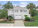 Charming two-story home featuring a well-manicured lawn and a two-car garage at 30 Beachside Dr, Isle of Palms, SC 29451
