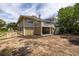 View of the back of the tan home, highlighting the deck, carport, and swing at 30 Beachside Dr, Isle of Palms, SC 29451