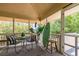 Relaxing screened porch with outdoor seating, a surfboard, and views of the surrounding greenery at 30 Beachside Dr, Isle of Palms, SC 29451