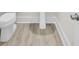 Close-up of a bathroom with white fixtures and wood-look flooring at 3029 Robeson Trce, Johns Island, SC 29455