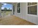 Inviting front porch featuring light wood flooring, light gray siding and a door with glass panes at 3029 Robeson Trce, Johns Island, SC 29455