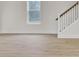 Bright living room featuring light wood flooring, crisp white walls, and a staircase with white risers and a wood banister at 3029 Robeson Trce, Johns Island, SC 29455