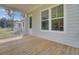 Inviting covered porch with wooden floor, white railing, and large windows to enjoy views at 3029 Robeson Trce, Johns Island, SC 29455