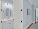 Powder room featuring white vanity, blue walls, mirror, and stylish lighting fixture at 3126-B Palmetto Blvd # 4, Edisto Island, SC 29438
