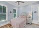 This bedroom has two windows, a ceiling fan, and pink bedding at 3126-B Palmetto Blvd # 4, Edisto Island, SC 29438