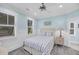 This bedroom has two windows, a ceiling fan, and striped bedding at 3126-B Palmetto Blvd # 4, Edisto Island, SC 29438