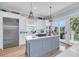 Modern kitchen with stainless appliances, island with cooktop, and adjacent bar seating near doors to outdoor deck at 3126-B Palmetto Blvd # 4, Edisto Island, SC 29438