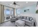 Comfortable living room with stylish furniture, ceiling fan, and an ocean view through glass doors at 3126-B Palmetto Blvd # 4, Edisto Island, SC 29438