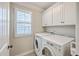 Bright laundry room featuring a side by side washer and dryer, a window, and cabinet storage at 3152 Riverine, Charleston, SC 29414