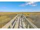 Picturesque marsh view featuring a wooden boardwalk with an overlook and seating leading to a serene nature preserve at 3152 Riverine, Charleston, SC 29414