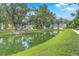 Scenic view of a tranquil pond surrounded by lush greenery and charming homes, creating a peaceful neighborhood setting at 3152 Riverine, Charleston, SC 29414