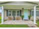 Inviting front porch with cozy seating, potted plants, and a light blue front door at 337 Price St, Goose Creek, SC 29445