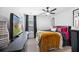 Modern bedroom featuring a ceiling fan, TV, large window, and stylish dark decor at 3506 Galaxy Rd, Ladson, SC 29456