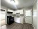 A kitchen with white cabinets, a black stove, and a view to the carpeted dining room at 36 Guerry Cir, Goose Creek, SC 29445