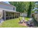 Spacious backyard featuring a screened porch, fire pit, and a detached storage building at 3813 Battleview Ct, North Charleston, SC 29420