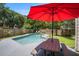 Relaxing backyard pool area with a picnic table and a bright red umbrella for shade at 3813 Battleview Ct, North Charleston, SC 29420