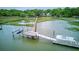 An aerial shot showcases a pier leading to a dock with boats alongside marshy land at 392 Tombee Ct, Mount Pleasant, SC 29464