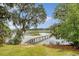 Stunning backyard featuring mature trees adorned with Spanish moss, overlooking a serene river with a wooden dock at 392 Tombee Ct, Mount Pleasant, SC 29464