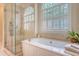 Bright bathroom boasting a soaking tub next to a window with plantation shutters and a glass shower at 392 Tombee Ct, Mount Pleasant, SC 29464