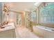 Luxurious bathroom with dual vanities, a glass-enclosed shower, and a soaking tub under a skylight at 392 Tombee Ct, Mount Pleasant, SC 29464