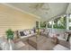 Beautiful covered porch with cozy seating, a ceiling fan, and serene views of the surrounding landscape at 392 Tombee Ct, Mount Pleasant, SC 29464