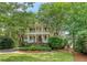 Stately two-story home with double balconies, lush landscaping, and a circular driveway, exuding charm at 392 Tombee Ct, Mount Pleasant, SC 29464
