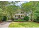 Stunning two-story home with double porches, lush landscaping, and a charming, tree-lined driveway at 392 Tombee Ct, Mount Pleasant, SC 29464