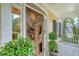 Inviting front door adorned with a wreath and lush potted plants on a charming porch at 392 Tombee Ct, Mount Pleasant, SC 29464
