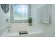Inviting bathroom boasts a soaking tub with decorative tile backsplash and a large window at 401 S Elgin Ct # 401, Charleston, SC 29414