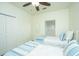 Cozy bedroom features two twin beds with striped blue accent pillows and a ceiling fan at 401 S Elgin Ct # 401, Charleston, SC 29414